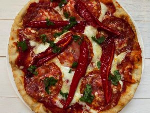 Pizza met pikante salami en geroosterde paprika