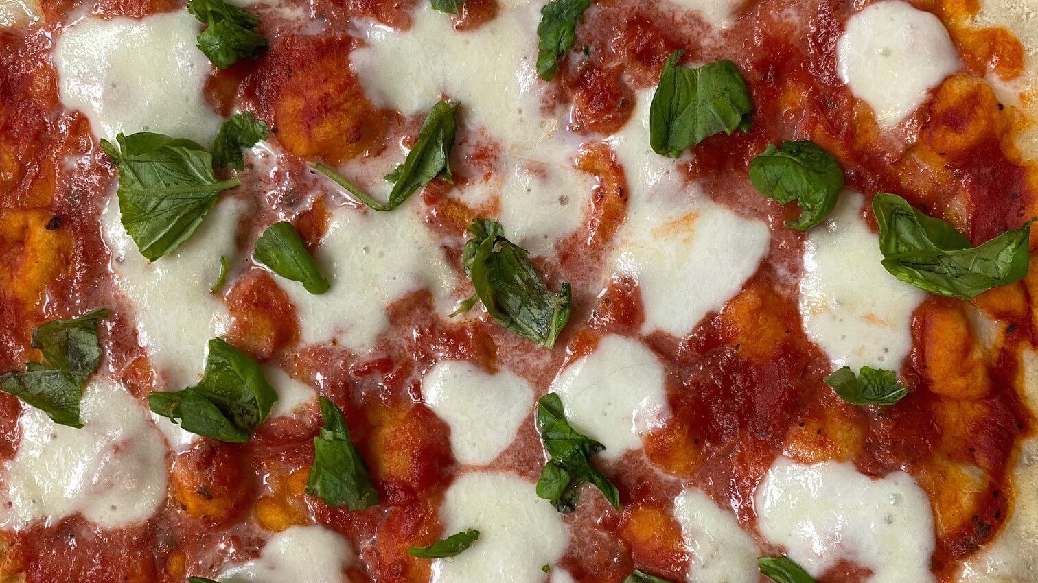 Pizza met tomaat, mozzarella en basilicum